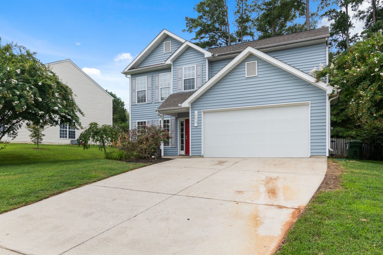 our-experience Charming two-story suburban house with spacious driveway and greenery.