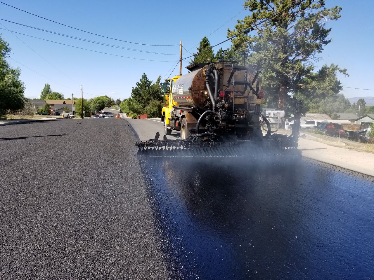 services-03 Road construction in Redmond, OR, with asphalt paving equipment. Sunny weather highlights the process.